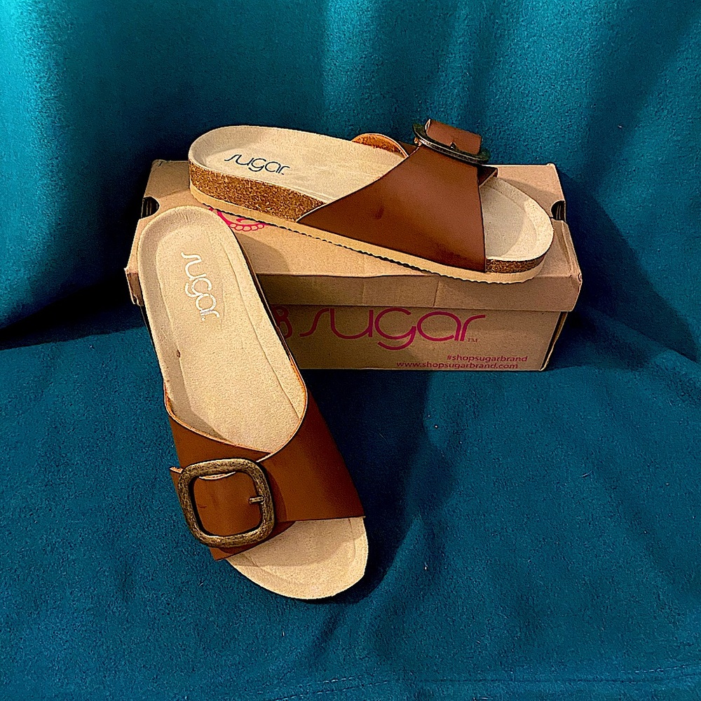 •Open toe
•Buckle detail
•Slip-on
•Lightly padded footbed
•Synthetic upper